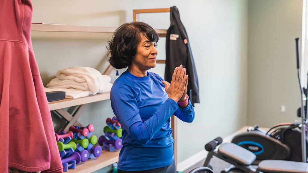 Yoga instructor standing with hands together